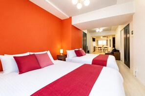 A hotel room with two beds, a red accent wall, and a view into the dining area. - Metro Gate Morishita (Tokyo)