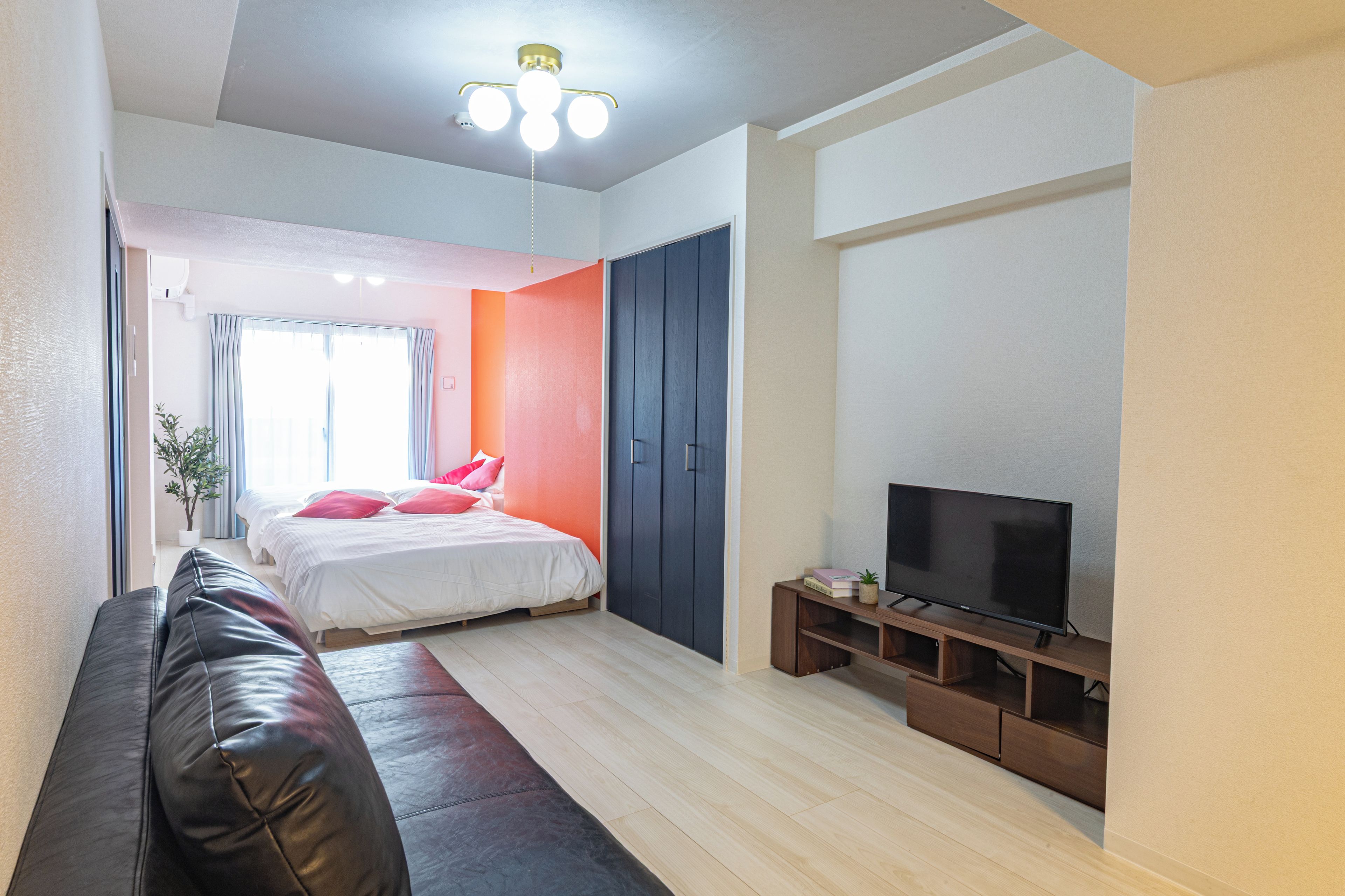 A modern bedroom with a bed, a TV, and a wardrobe.