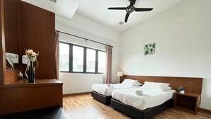 A hotel room with two beds, a desk, a ceiling fan, and a window with curtains. - The Retreat Sunriseview Cameron highland (Brinchang)