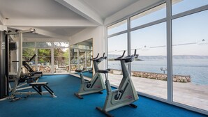 A gym with cardio machines and a view of a body of water. - Beautiful Apartments in Jelsa, With Pool (Jelsa)