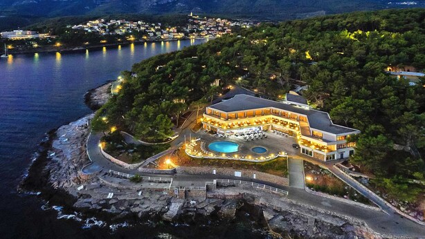 A coastal hotel with a swimming pool, surrounded by trees and overlooking a body of water. - Beautiful Apartments in Jelsa, With Pool (Jelsa)