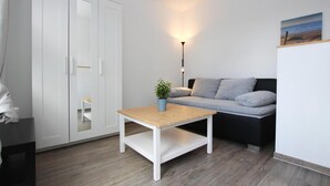 Un salon moderne avec un canapé, une table basse et une armoire.