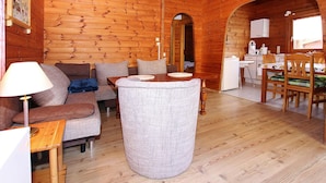 A wooden cabin interior with a sofa, table, and chairs. - Blockhaus, Hasselfelde (Oberharz am Brocken)