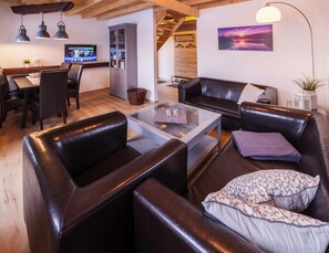 Relax in this stylish living room with a leather sofa, glass coffee table, and flat-screen TV.