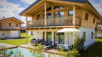 Enjoy a relaxing stay in this cabin with a spacious balcony, large windows, and a covered patio area perfect for outdoor seating.