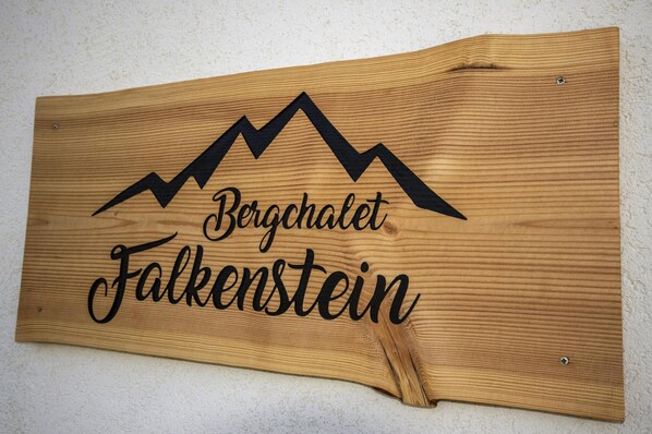 A wooden sign with the text "Bergkletz Falkenstein" and a mountain graphic.