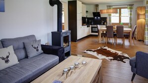A modern living room with a sofa, coffee table, and a fireplace. - Bergchalet Falkenstein, Inzell (Inzell)