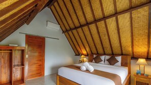 A bedroom with a wooden bed, a nightstand, a wardrobe, and a sloped ceiling with a woven texture. - La Rise Penida Cottage (Penida Island)
