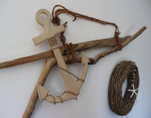 Une ancre en bois et une corde attachées à une branche, le tout agrémenté d’une décoration en forme d’étoile de mer.