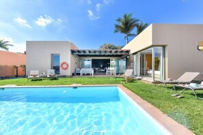 A modern house with a swimming pool, outdoor seating, and a covered patio area. - Holiday Home, Maspalomas (San Bartolomé de Tirajana)
