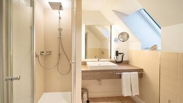 Une salle de bain moderne avec une douche, un lavabo et un miroir.