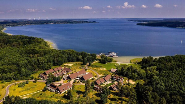 An aerial view of a residential area with houses, a marina, and a large body of water. - Appartement am Plauer See in Ganzlin (Ganzlin)