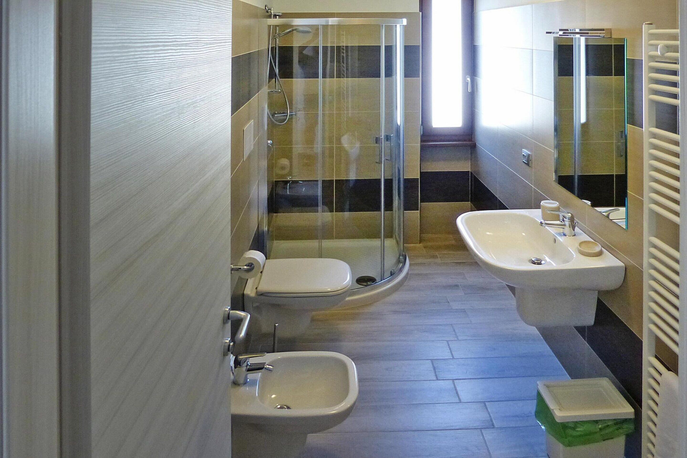 Une salle de bain avec une douche à parois de verre, un lavabo et un bidet.
