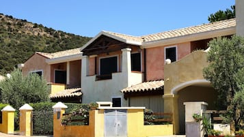 Um edifício residencial com fachada simétrica, várias janelas e telhado em telhas.