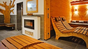 A wooden cabin interior with a fireplace, benches, and a unique wooden bed structure. - Apartment in Wildschonau by Schatzberg Lift (Wildschönau)