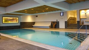 An indoor swimming pool with a wooden ceiling, a bench, and a staircase leading to an upper level. - Apartment in Wildschonau by Schatzberg Lift (Wildschönau)