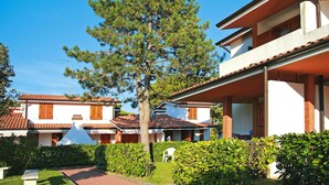 A residential building with a red-tiled roof, white walls, and a balcony. - Apartment in Italy Near Sandy Beach (San Michele al Tagliamento)