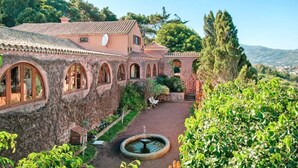 A traditional building with arched windows and a courtyard with a fountain. - Villa Mansion Bandama, Santa Brigida (Santa Brigida)
