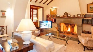 A cozy living room with a fireplace, comfortable seating, and a television. - Villa Mansion Bandama, Santa Brigida (Santa Brigida)