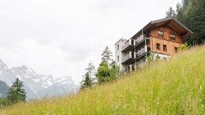 Un chalet en bois doté d’un balcon, situé dans un cadre montagneux.