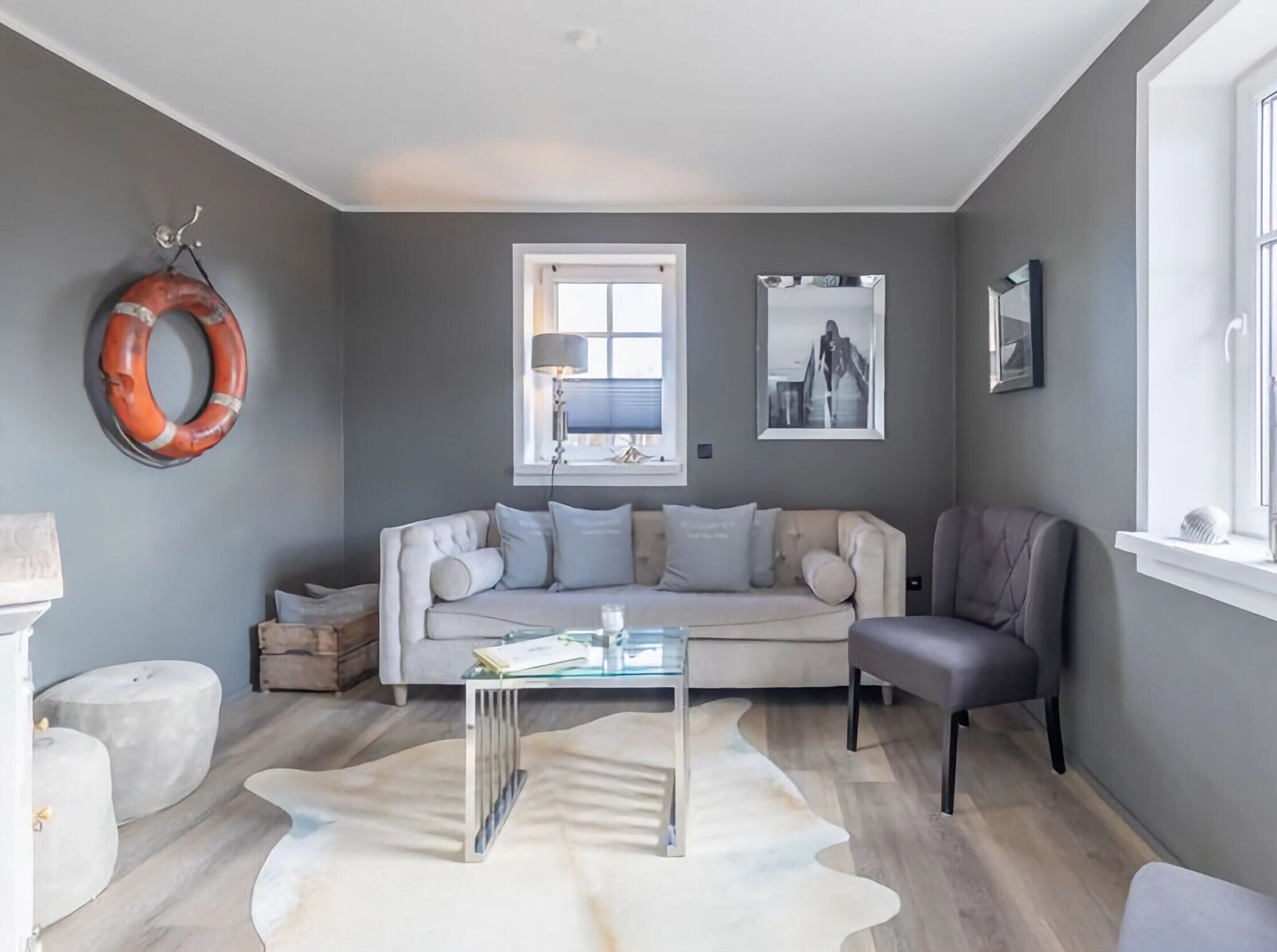 A living room with a sofa, a coffee table, a chair, a lamp, and a window with a view.
