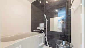 A modern bathroom with a bathtub, a glass shower enclosure, and a mirror. - UTOPIA 101 (Sapporo)
