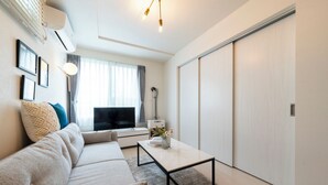 Ein modernes Wohnzimmer mit einer Couch, einem Couchtisch und einem Fernseher.