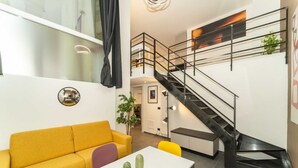 A modern interior with a yellow sofa, a white table, and a black staircase. - GuestHost - Galaxy Lofts - Appt Jupiter x4 (Torino)