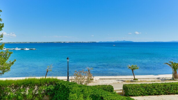 A coastal view with a clear blue sky, a sandy beach, and a calm sea. - Apartment on Vir Island Near Sandy Beaches (Vir)