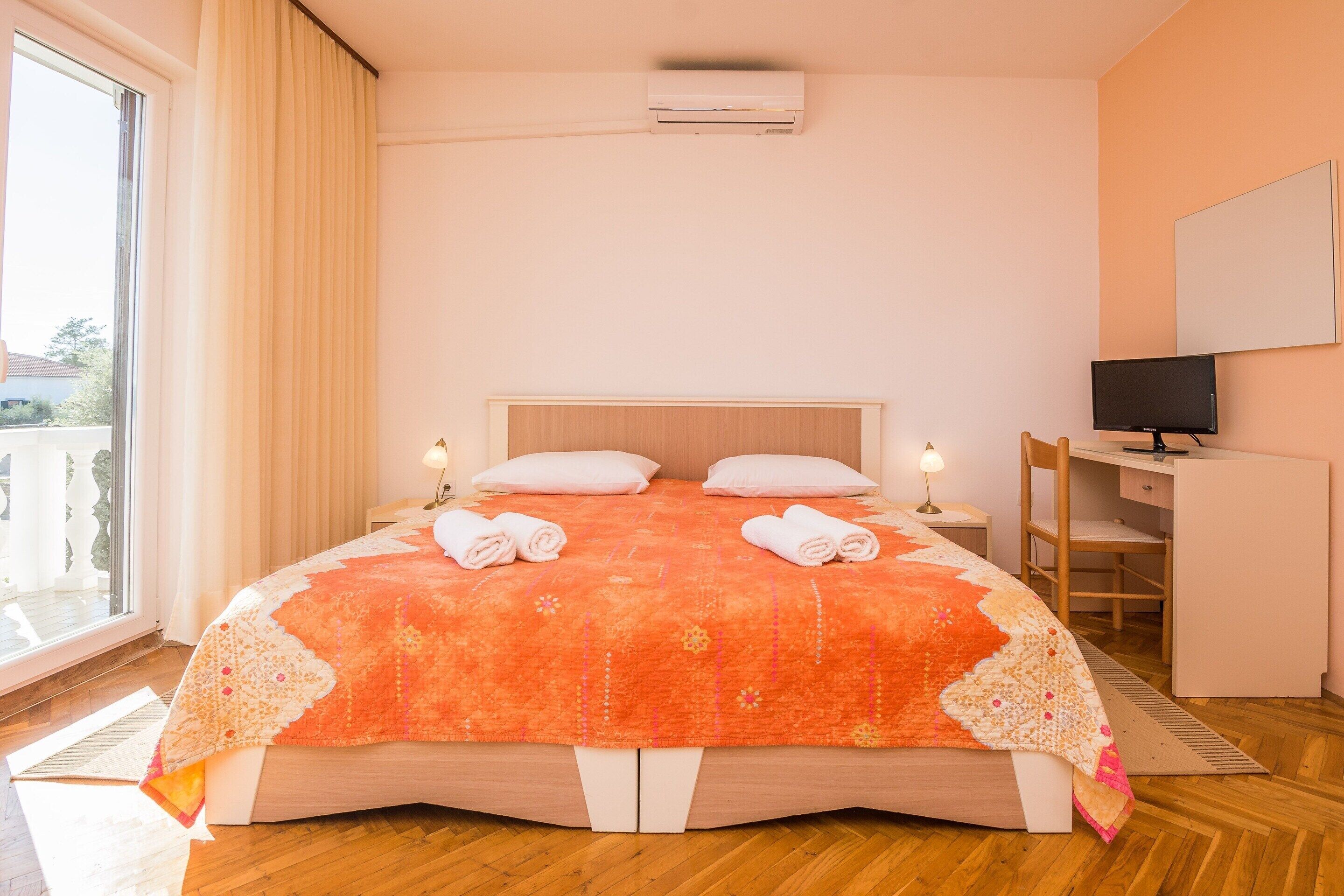 Une chambre à coucher avec un lit, un bureau et une télévision.