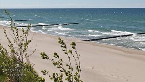 A beach with clear skies, waves, and a sandy shore. - Apartment Near Baltic Sea With Balcony View (Rewal)