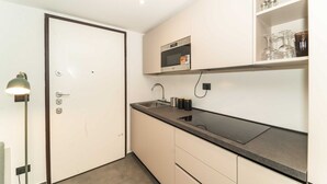 A compact kitchen with a microwave, sink, and countertop. - GuestHost - Galaxy Lofts - Appt Saturn x4 (Torino)