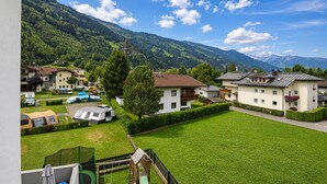 Un barrio residencial con casas, un parque infantil y una montaña al fondo.