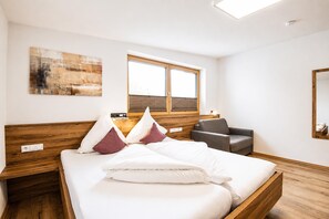 A hotel room with a bed, a chair, a window, and a painting on the wall. - Holiday Home in Aschau Near Climbing Center (Aschau Im Zillertal)