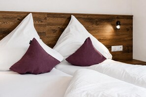 A bed with white bedding and two dark purple pillows. - Holiday Home in Aschau Near Climbing Center (Aschau Im Zillertal)