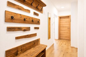 A hallway with wooden wall-mounted shelves and a bench. - Holiday Home in Aschau Near Climbing Center (Aschau Im Zillertal)