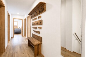 A hallway with wooden flooring, a bench, and a wall-mounted coat rack. - Holiday Home in Aschau Near Climbing Center (Aschau Im Zillertal)