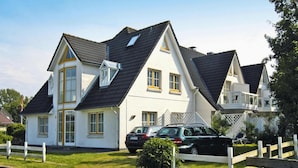 A two-story house with a gabled roof, large windows, and a balcony. - Ferienwohnung in St. Peter-ording (St. Peter-Ording)