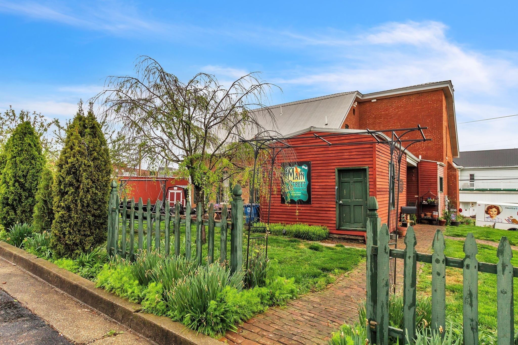 A red brick building with a green door and a sign that reads "Main Street."