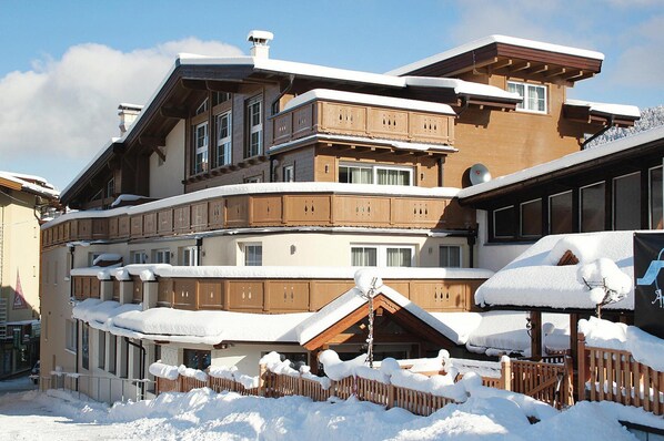 A multi-story hotel with a traditional architectural style, featuring balconies and wooden railings.