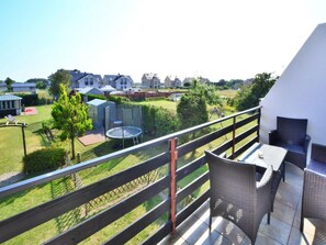 A balcony with outdoor furniture, a trampoline, and a view of a residential area. - Grosse, Komfortable Villa mit Privatem Garten (Ustronie Morskie)
