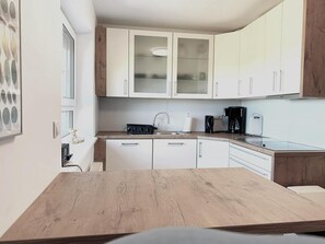A modern kitchen with white cabinets, a wooden countertop, and a coffee maker. - Grosse, Komfortable Villa mit Privatem Garten (Ustronie Morskie)