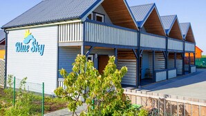 A building with a blue and white exterior, a sign reading "Blue Sky," and a covered outdoor area with benches. - Holiday Home in Rewal Near Baltic Beach (Rewal)
