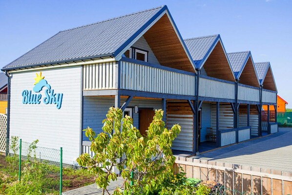 Un bâtiment sur lequel on peut lire l’inscription « Blue Sky », et une zone ext érieure abritée avec des bancs.