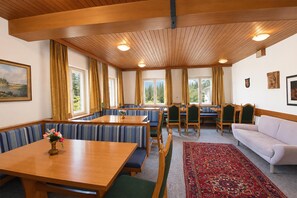 A room with a wooden ceiling, a dining table with benches, a sofa, and a patterned rug. - Chalet in Fugen Near Spieljochbahn (Fuegen)