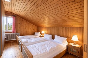 A wooden-paneled room with two beds, a window with a view of trees, and a radiator. - Chalet in Fugen Near Spieljochbahn (Fuegen)
