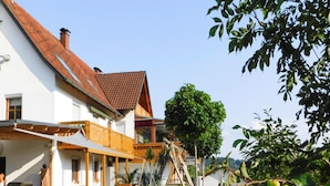A traditional house with a tiled roof, a wooden balcony, and a hammock. - Apartment in Veringendorf Near Swabian Alb (Veringenstadt)