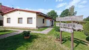 A building with a red roof and a sign reading "FALA" with a phone number. - Holiday Apartment in Kopalino (Choczewo)