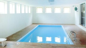 A swimming pool with a tiled floor and a metal ladder. - Apartment Santa Lucia in Bezecca (Ledro)