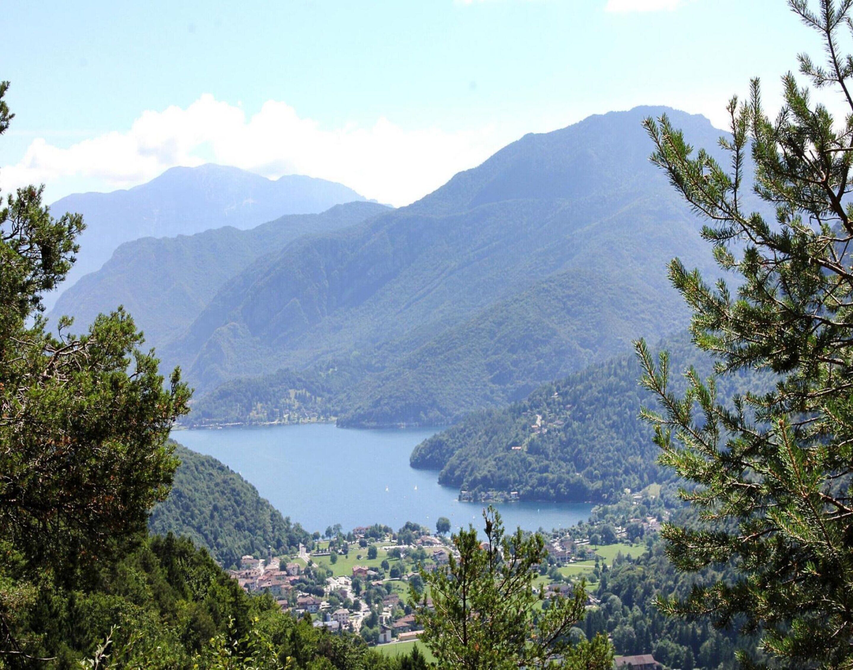 Un paysage montagneux avec un lac et une ville située dans la vallée.